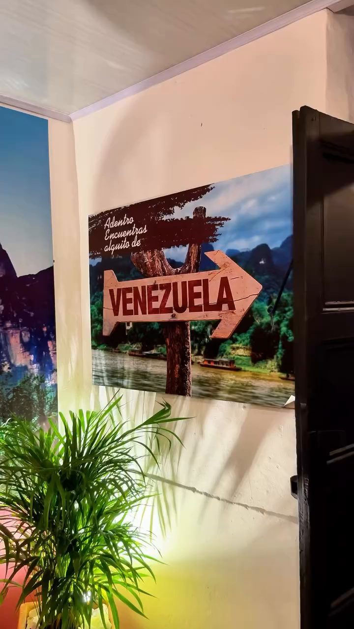 Pasillo de La Esquina Venezolana con murales, matas y el letrero de Venezuela