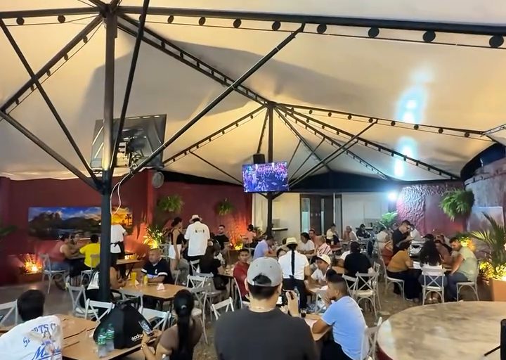Salón de La Esquina Venezolana lleno de comensales bajo la carpa